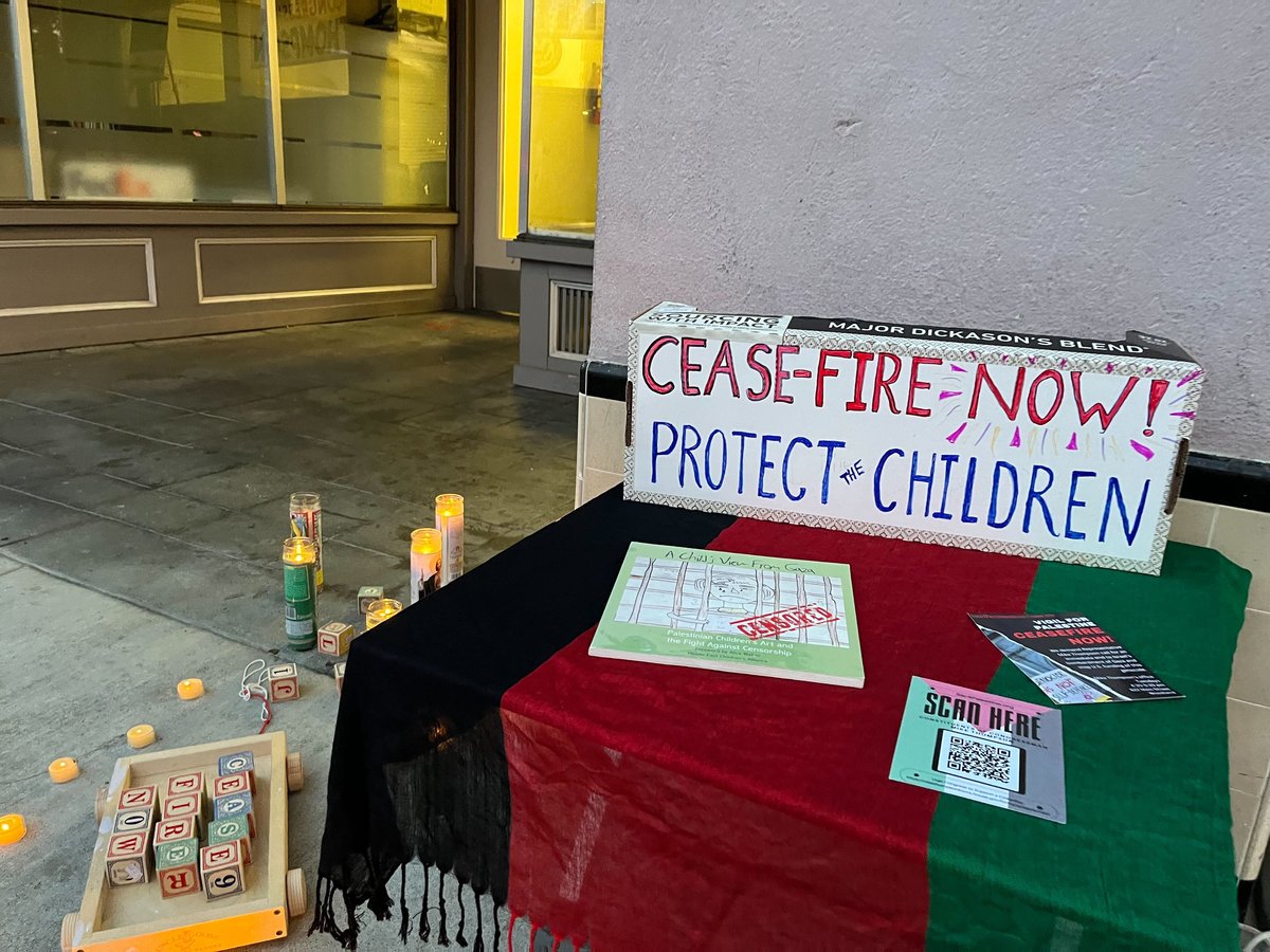 The Palestinian flag is draped over a table on which information and a children’s book about life in the Gaza Strip at a Dec. 5, 2023 vigil in Woodland, Calif.