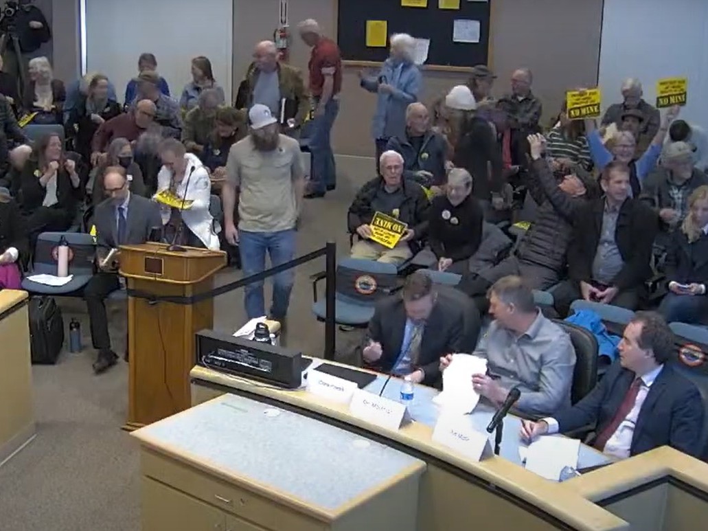 At the Nevada County Board of Supervisors meeting on Feb. 16, locals holding “No Mine” signs celebrated the decision to reject the Rise Gold project. Ben Mossman, the former CEO of Rise Gold, is pictured sitting in the middle seat of the table.