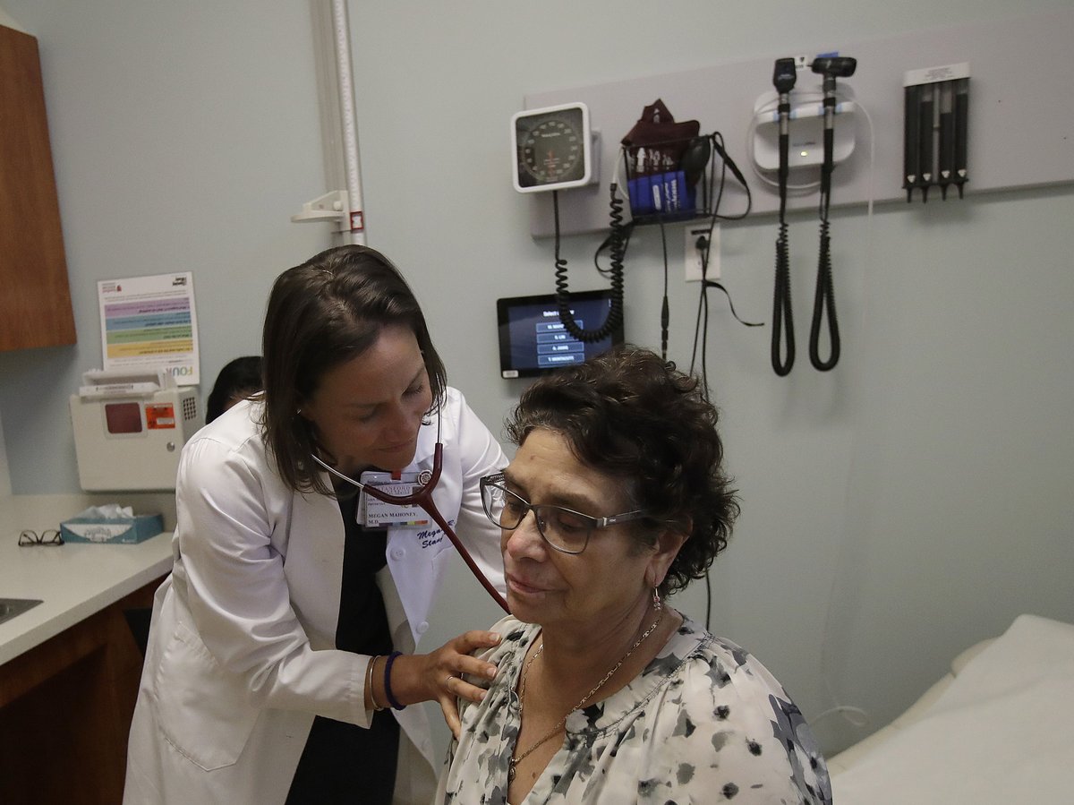 In this April 9, 2019 photo, Dr. Megan Mahoney, left, examines patient Consuelo Castaneda at the Stanford Family Medicine office in Stanford, Calif.