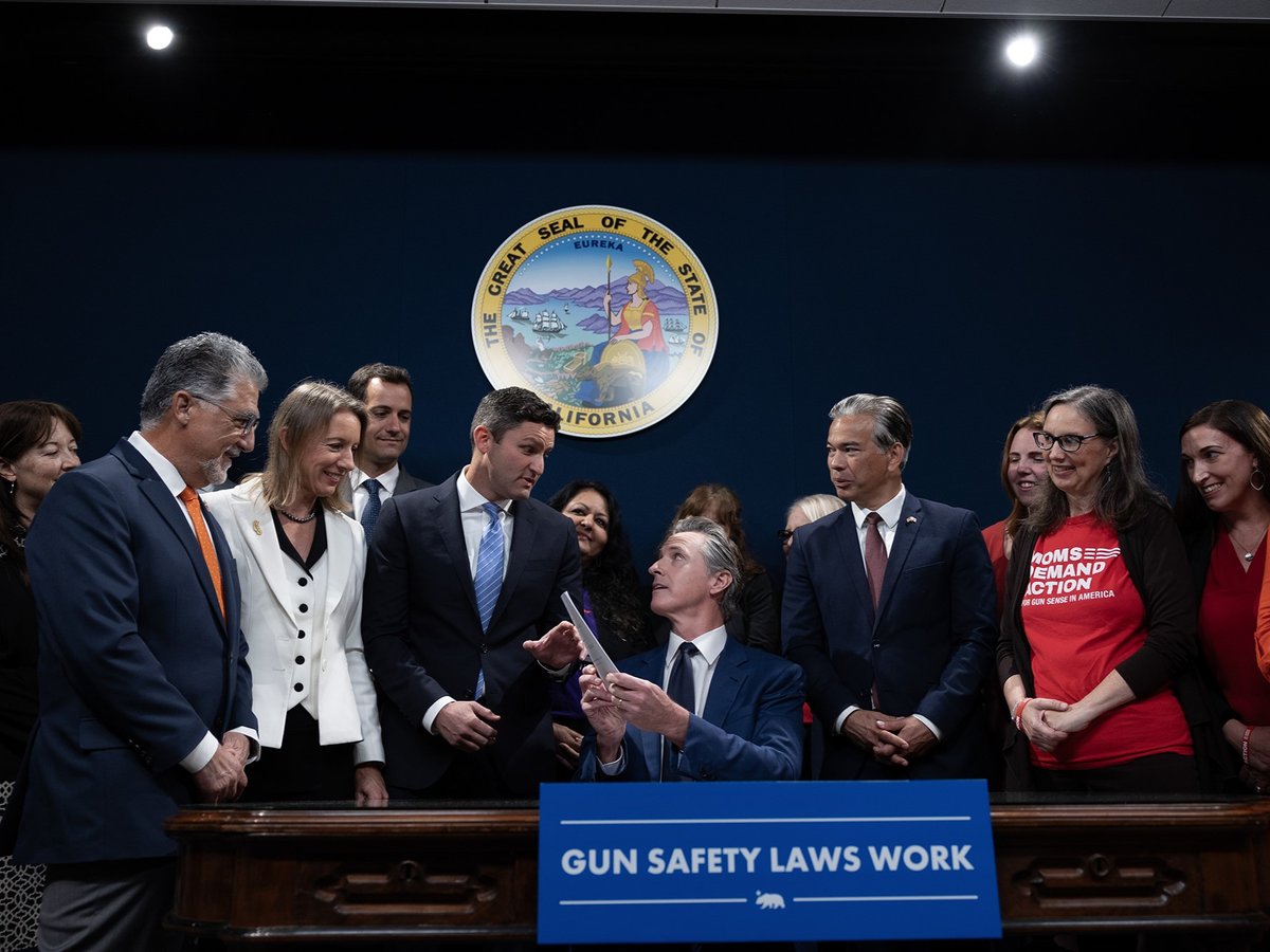 Flanked by lawmakers and gun safety advocates, Gov. Gavin Newsom signs new gun legislation into law in Sacramento on Sept. 26, 2023.