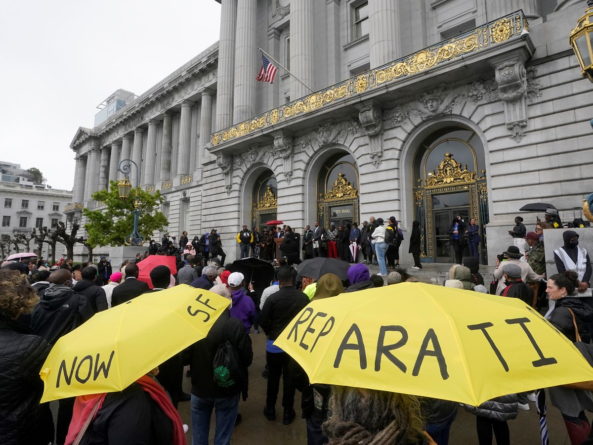 A crowd listens to speakers at a reparations rally outside of City Hall in San Francisco, on March 14, 2023.