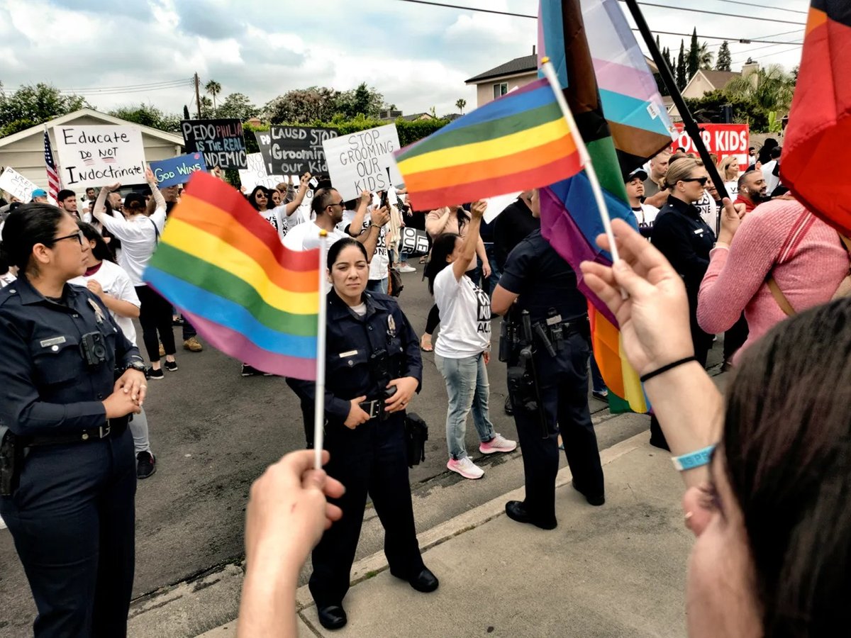 LGBTQ counter-protesters wave Pride Flags as Los Angeles police officers separate them from protesters at the Saticoy Elementary School in North Hollywood on June 2, 2023.