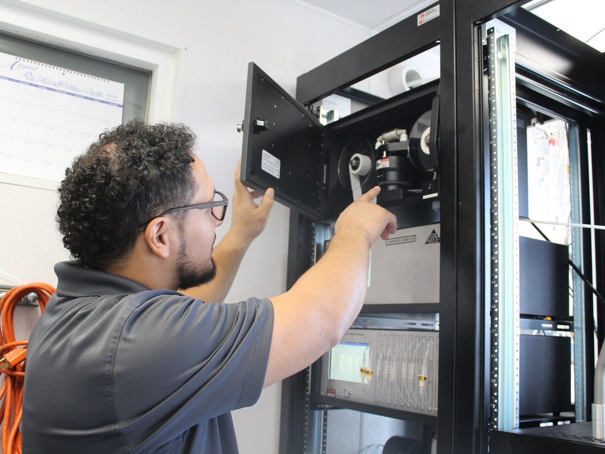 Air Quality Specialist Nicolas Gonzalez shows equipment inside a mobile air monitoring lab outside Fern Bacon Middle School in Sacramento on Aug. 9, 2024.