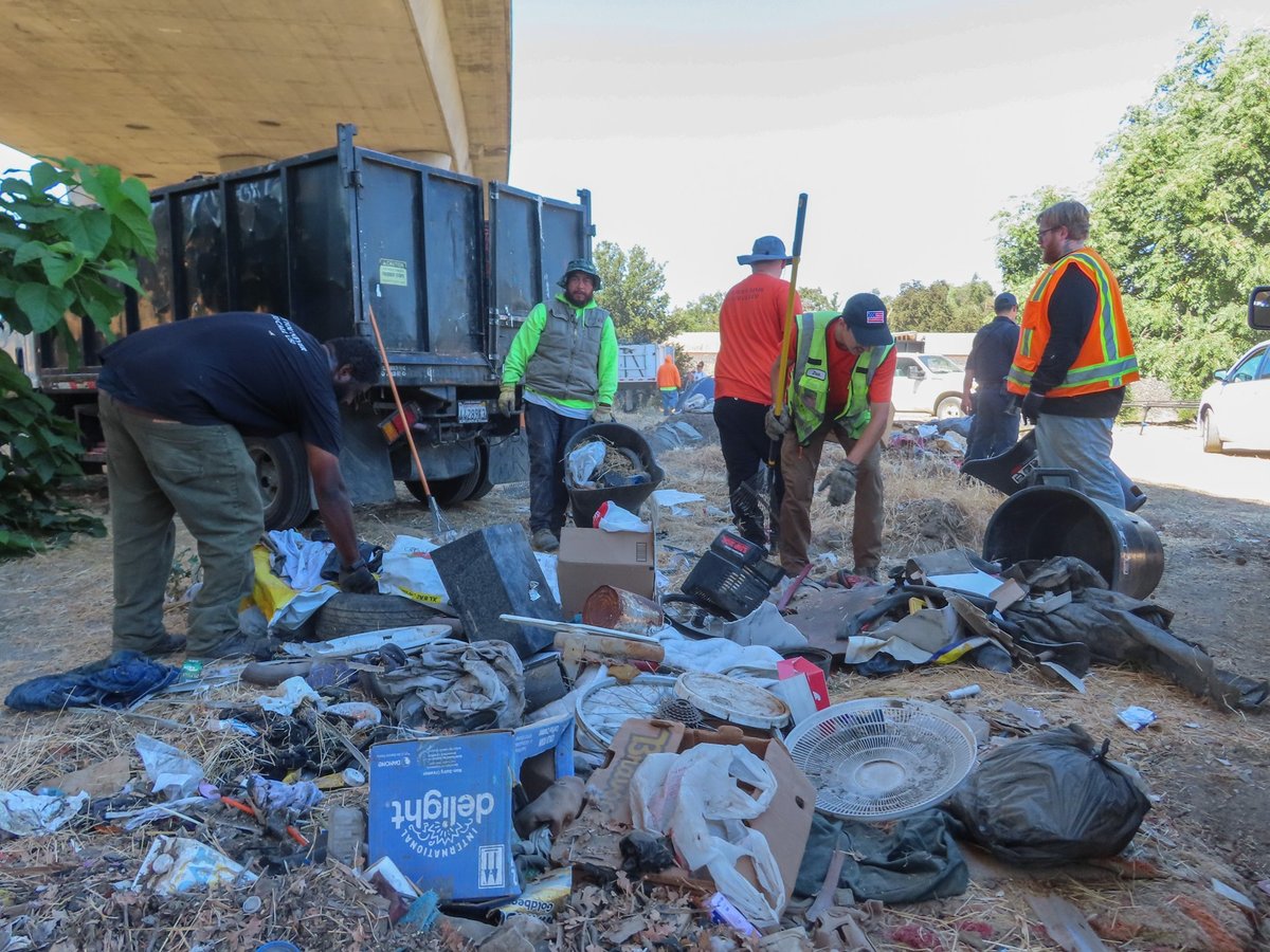 Sacramento Department of Community Response staff clear a trash pile near an encampment next to the former Camp Resolution site on Wednesday, Sept. 4, 2024, in Sacramento.