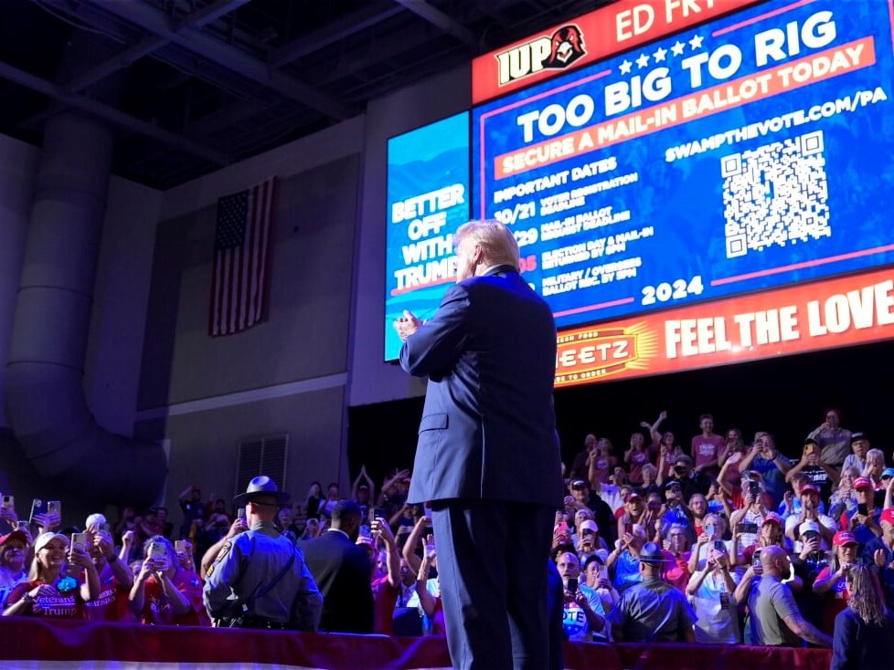 Former President Donald Trump stands on stage after speaking at a campaign event in Indiana, Pa., on Sept. 23. Behind Trump, Republicans are urged to vote in numbers that are "too big to rig."