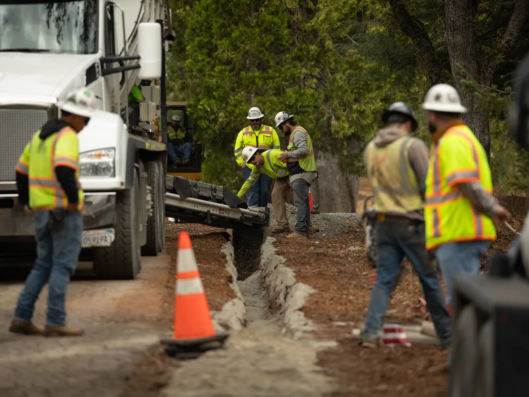 Contractors with PG&E work in a trench to lay underground electric cables in Placer County on Oct. 17, 2024. Burying lines and other wildfire prevention projects have raised the price of electricity in California.