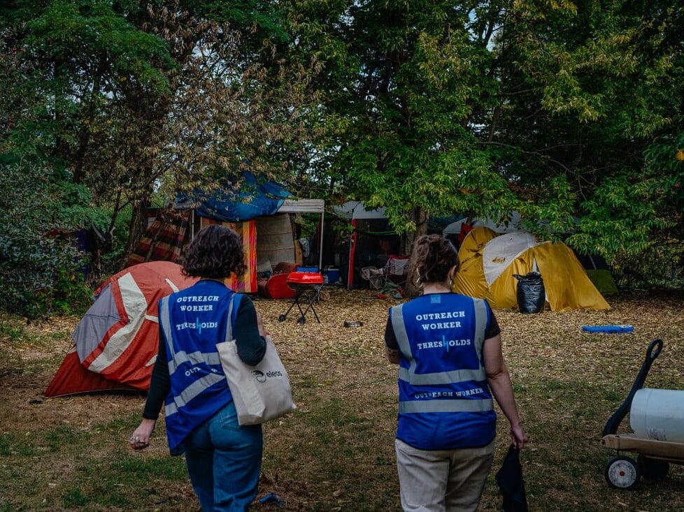 The burst of new laws follows a landmark U.S. Supreme Court ruling and reflects public frustration with record-high homelessness. Outreach workers Lillian Risser (left) and Sophia Loveland approach a tent encampment in Chicago on Sept. 23, 2024.