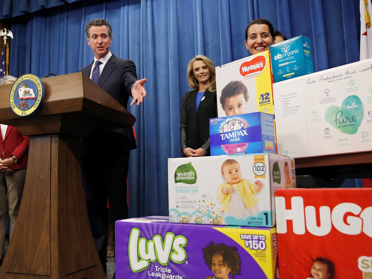 In this May 7, 2019, file photo, Gov. Gavin Newsom gestures towards boxes of tampons and diapers after proposing to eliminate from the state sales tax on such products in his upcoming state budget during a news conference in Sacramento, Calif.