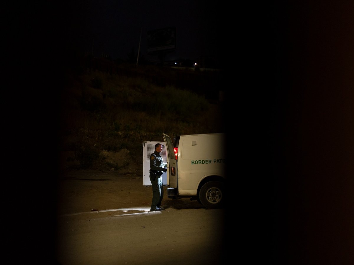 A Border Patrol agent loads migrants seeking asylum into a van to be processed, Tuesday, June 4, 2024, in San Diego.