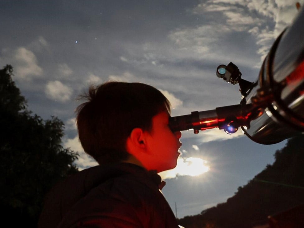 A youth looks through a telescope during a stargazing and comet-watching gathering at Joya-La Barreta Ecological Park in Queretaro, Mexico, on Oct. 19, 2024.