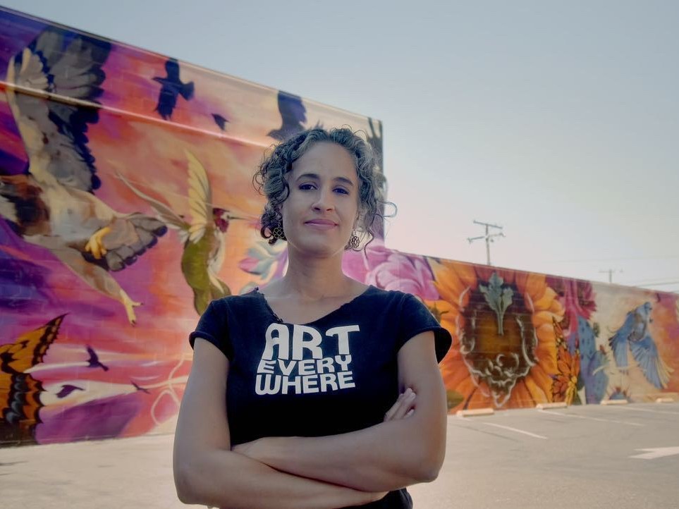 Sacramento Muralist Jaya King stands in front of a project that was part of the Community Murals Sacramento program.