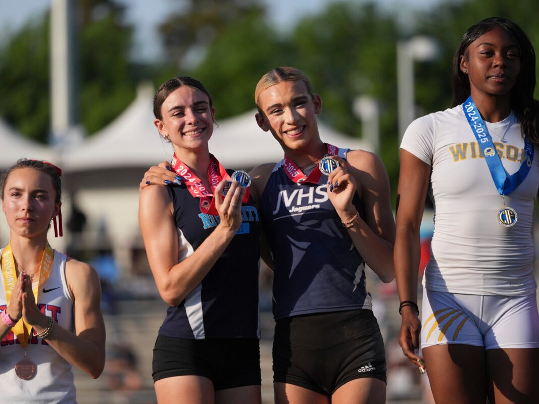 Flanked by fourth-place winner Ellie McCuskey-Hay, left, and first-place winner Loren Webster, right, second-place winners AB Hernandez, center right, and Brooke White share the podium during a medal ceremony for the long jump.
