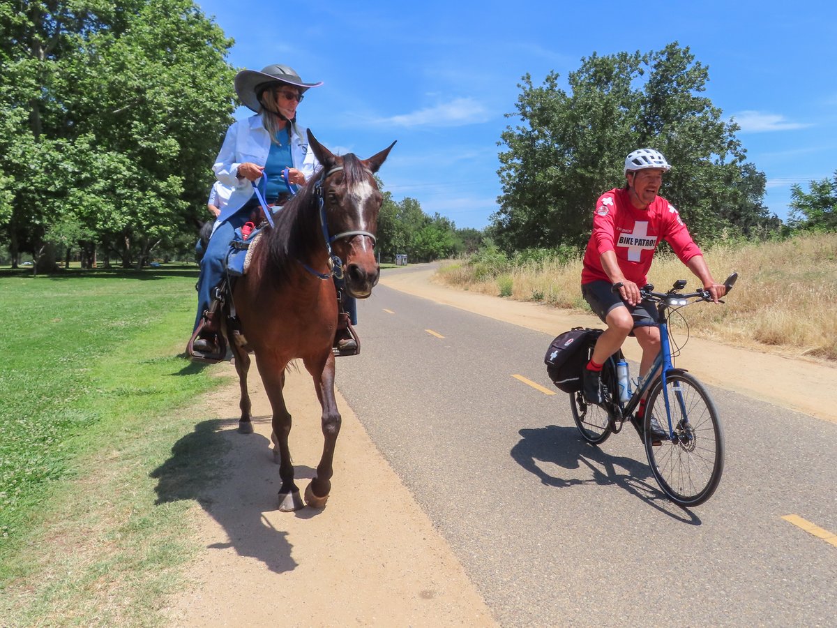 American River Bike Patrol spokesman Vic Massenkoff and Jeanlaurie Ainsworth with the American River Equestrian Patrol demonstrate how bicyclists should pass horses Thursday, May 29, 2025, along the American River Bike Trail in Carmichael.