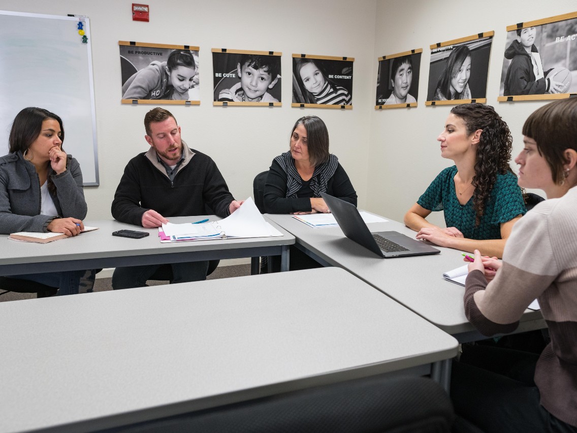 Erin Kennedy, Scott Dinits, Rashell Brobst, Lindsey Nenadal, and Courtney Peria work on the playbook to support children after a wildfire.