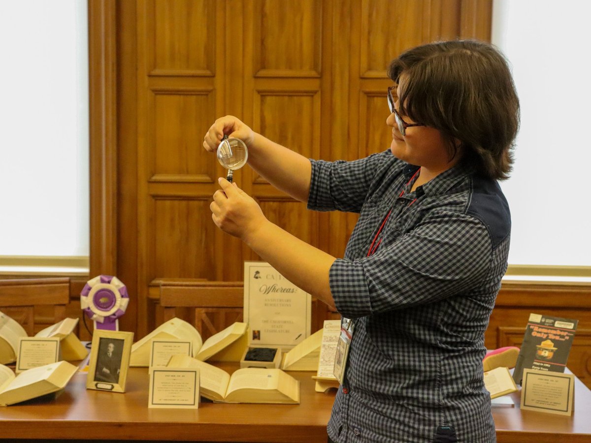 Kim Sims, a librarian at the California State Library, holds a vial of gold flakes as part of a display for the Sacramento Archives Crawl. Thursday, Sept. 25, 2025.