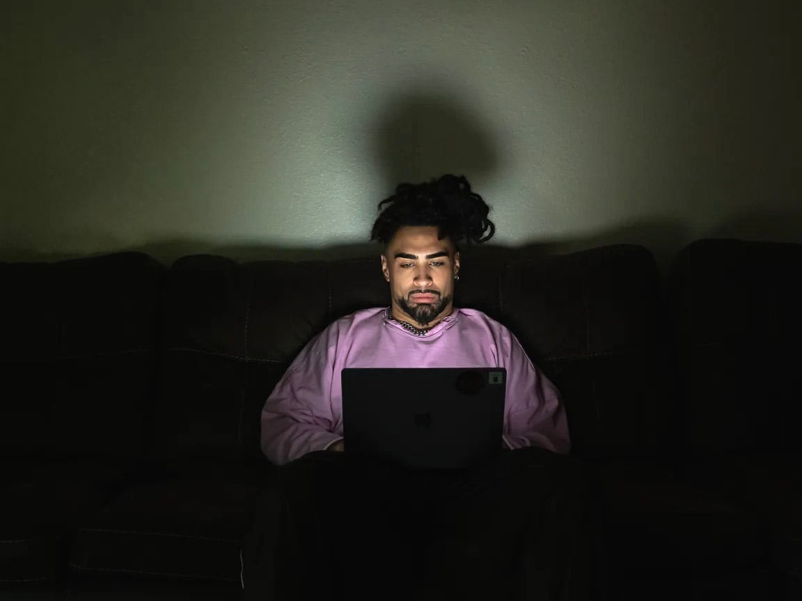 Jodeah Wilson, 22, on his laptop at his off-campus apartment near Sacramento State University on Oct. 17, 2025. Wilson, a former Sac State student, left school this semester after being unable to afford tuition.