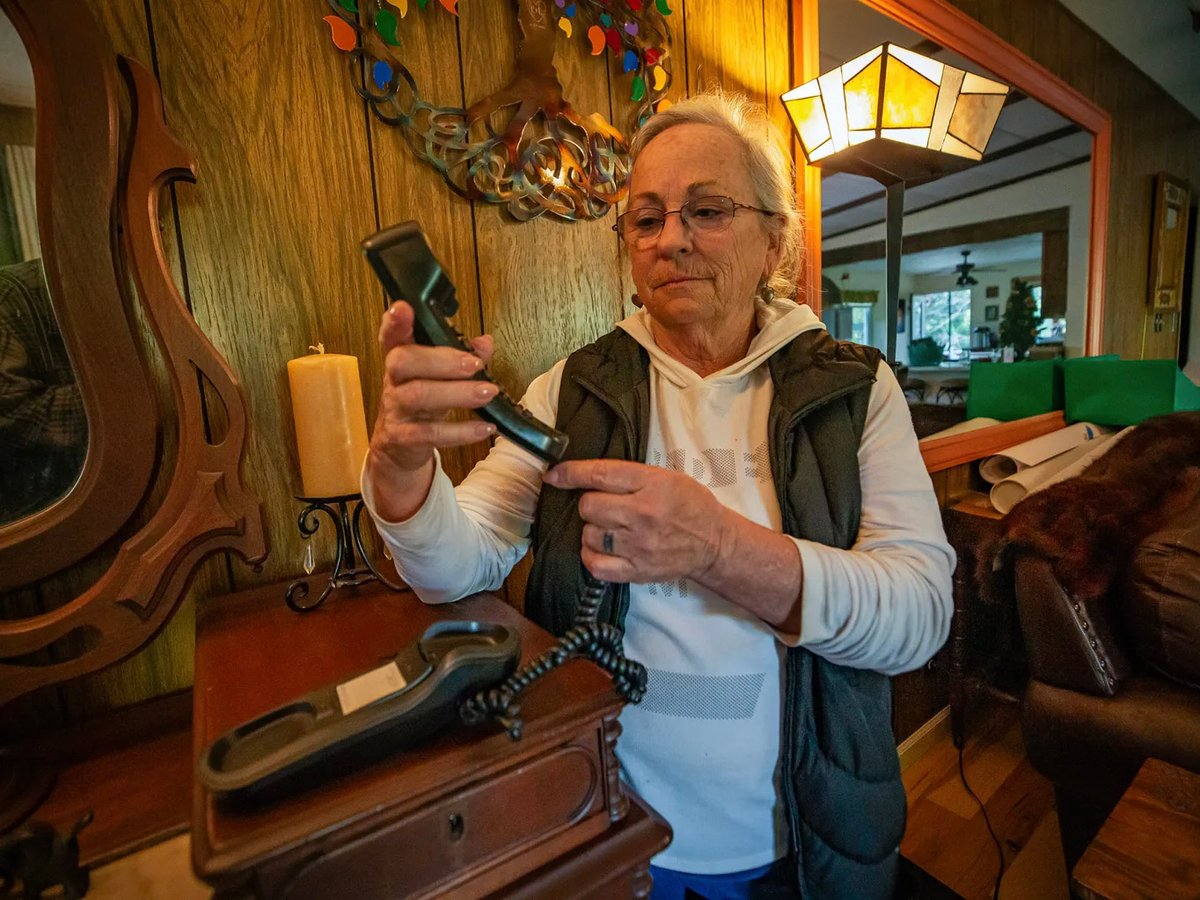Hacienda resident Cynthia Halliday checks for a dial tone on her landline phone at her home above the Russian River in Sonoma County, Oct. 23, 2025. Halliday lost her husband to a heart attack and could not stay connected to 911 on her cell phone.