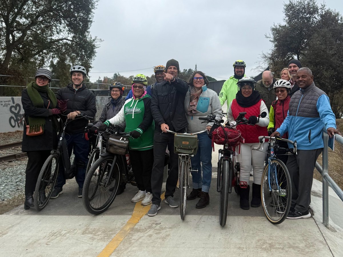 Pedestrians and council members celebrate the reopening of the Del Rio Trail Bridge.