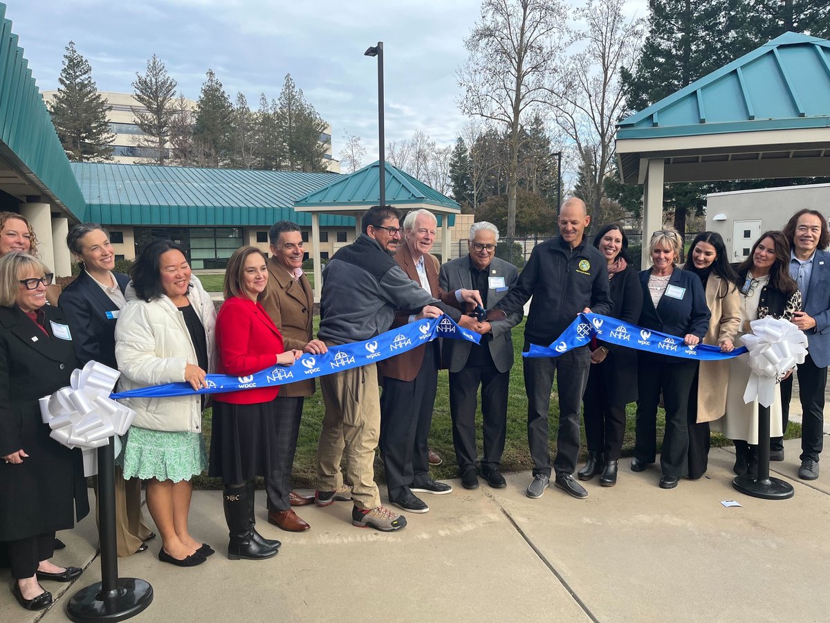 Local leaders and health care providers pose for a ribbon cutting ceremony at Community Care Center, Sacramento's newest and largest recuperative health care center for unhoused people exiting hospitals, Dec. 16, 2025.