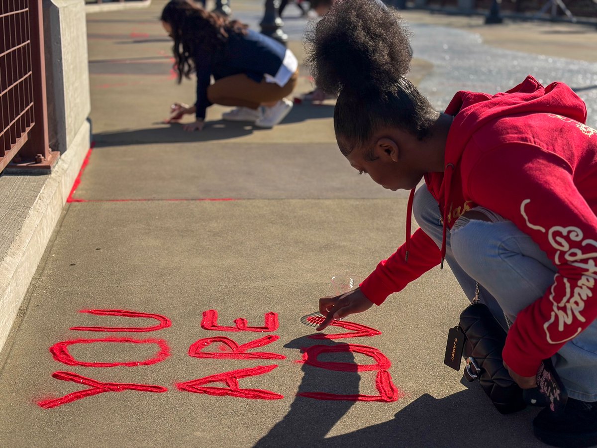 A participant pours red sand into a message during a Red Sand Project event at Roseville’s Royer Park on Jan. 15, 2026.