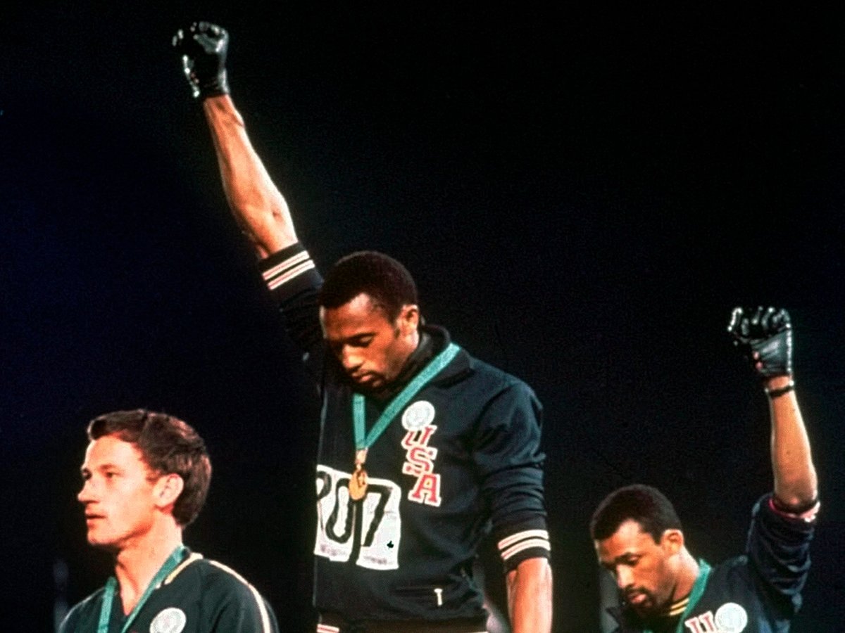 FILE - In this Oct. 16, 1968, file photo, Australian silver medalist Peter Norman, left, stands on the podium as Americans Tommie Smith, center, and John Carlos raise their gloved fists in a human rights protest.