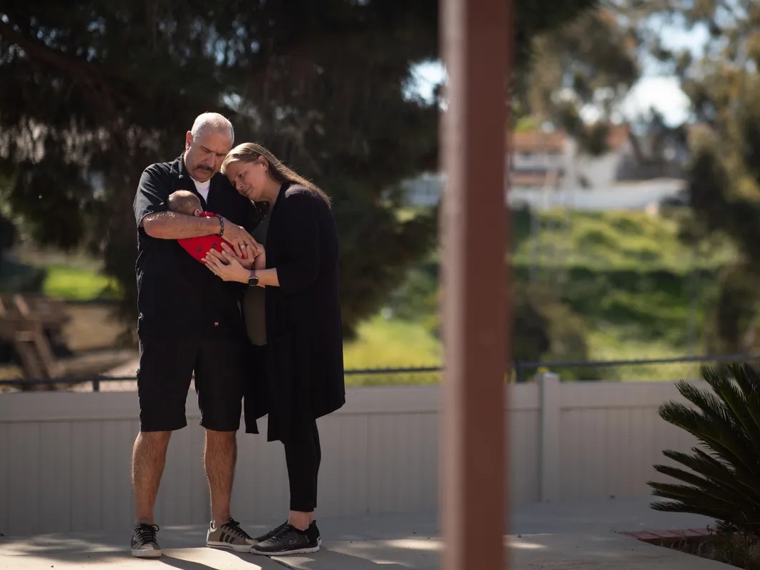 Tony and Sara Iagmin hold a three-month-old baby they are fostering at their home in San Diego’s Lakeside neighborhood on Feb. 23, 2026.