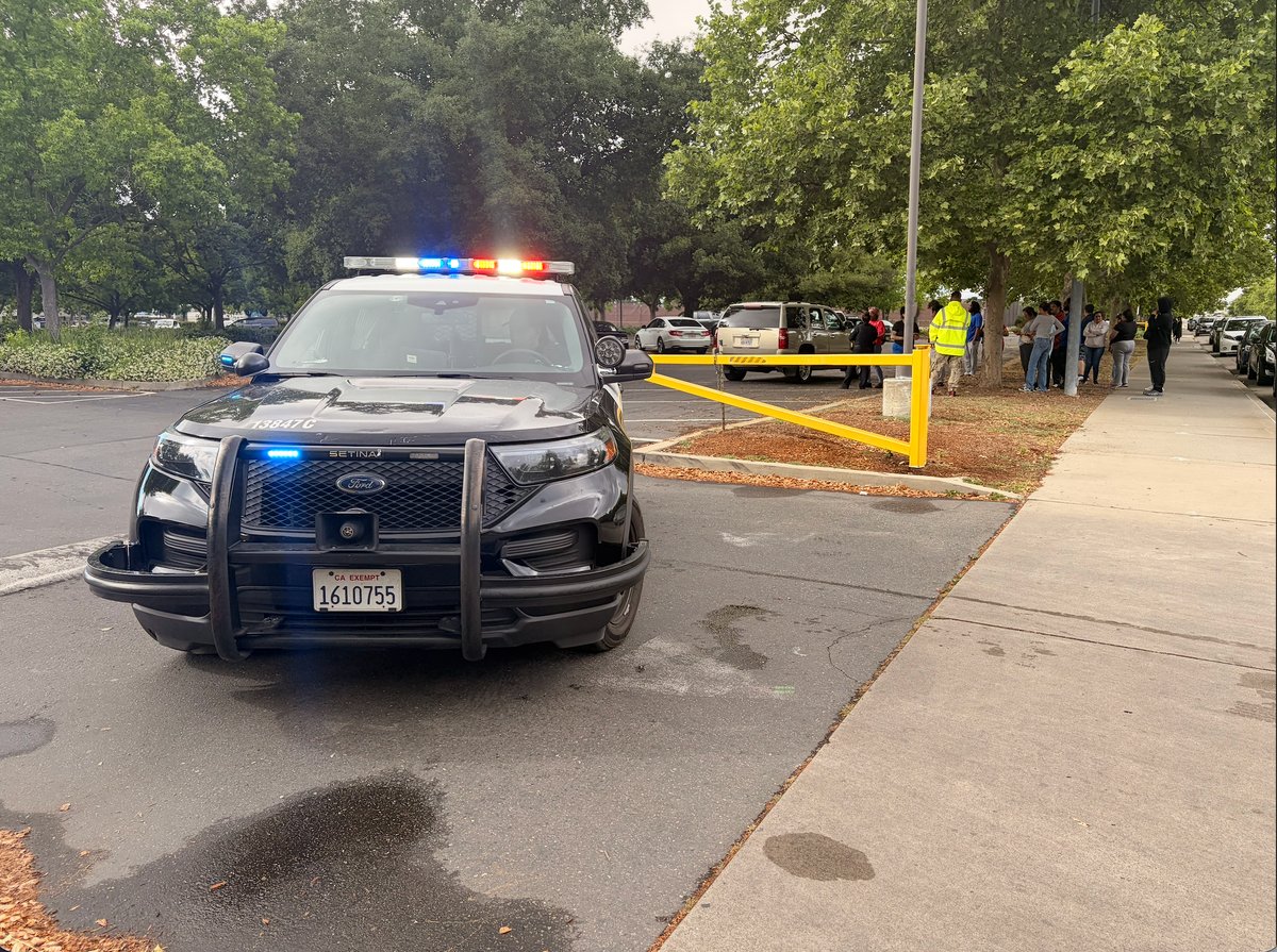 Parents and law enforcement gather outside Natomas High School in Sacramento on April 10, 2026, after a shooting on campus. A 16-year-old was killed and police launched a search for a suspect.