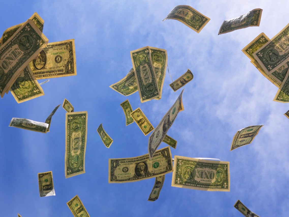 U.S. one-dollar bills are seen against the sky in Dallas, Tuesday, April 7, 2026.