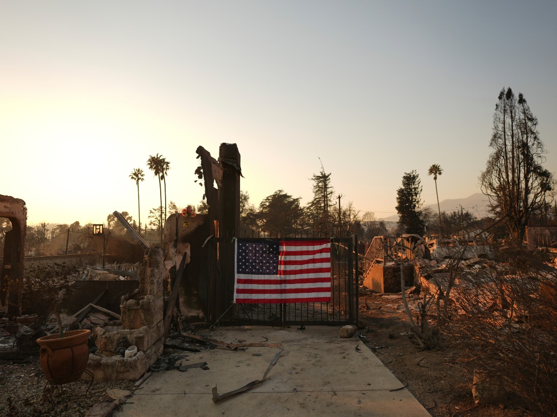 FILE - An American flag hangs on the gate of a home destroyed by the Eaton Fire in Altadena, Calif., Jan. 10, 2025.