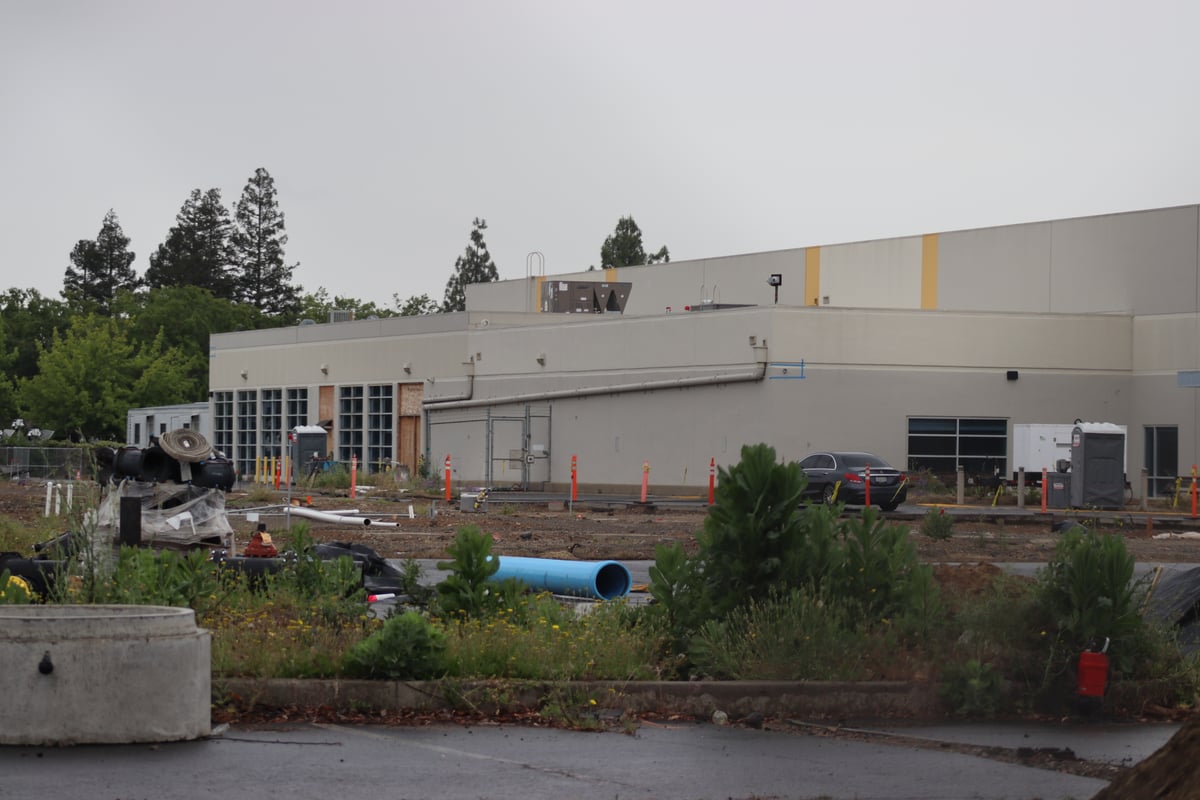 A fenced-off warehouse under construction at the Watt Avenue shelter site in North Highlands on May 4, 2026. The county purchased the property in 2022 for about $23 million.