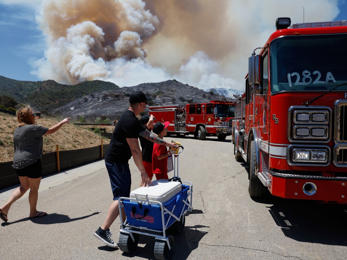 Matt and Kim Brantley bring firefighters snacks and refreshments with their kids during wildfires, Tuesday, May 19, 2026, in Simi Valley, Calif.