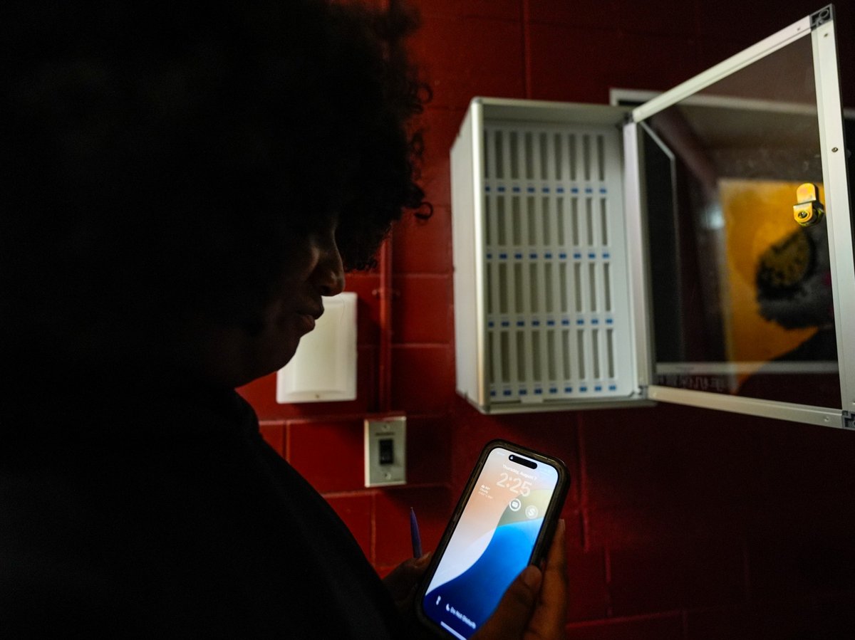 Student Audreanna Johnson views her cell phone near a cell phone locker at Ronald McNair Sr. High School, Thursday, Aug. 7, 2025, in Atlanta.