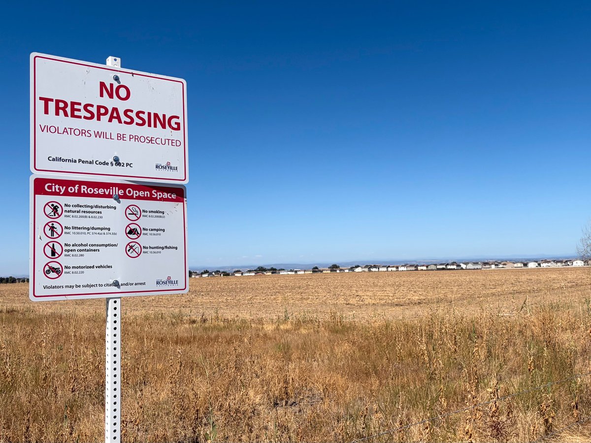 A City of Roseville Open Space sign and no-trespassing warnings mark the fence line at the Phillip Road site on July 9, 2026. The city owns the roughly 240-acre parcel and is reviewing a developer's application to rezone it.