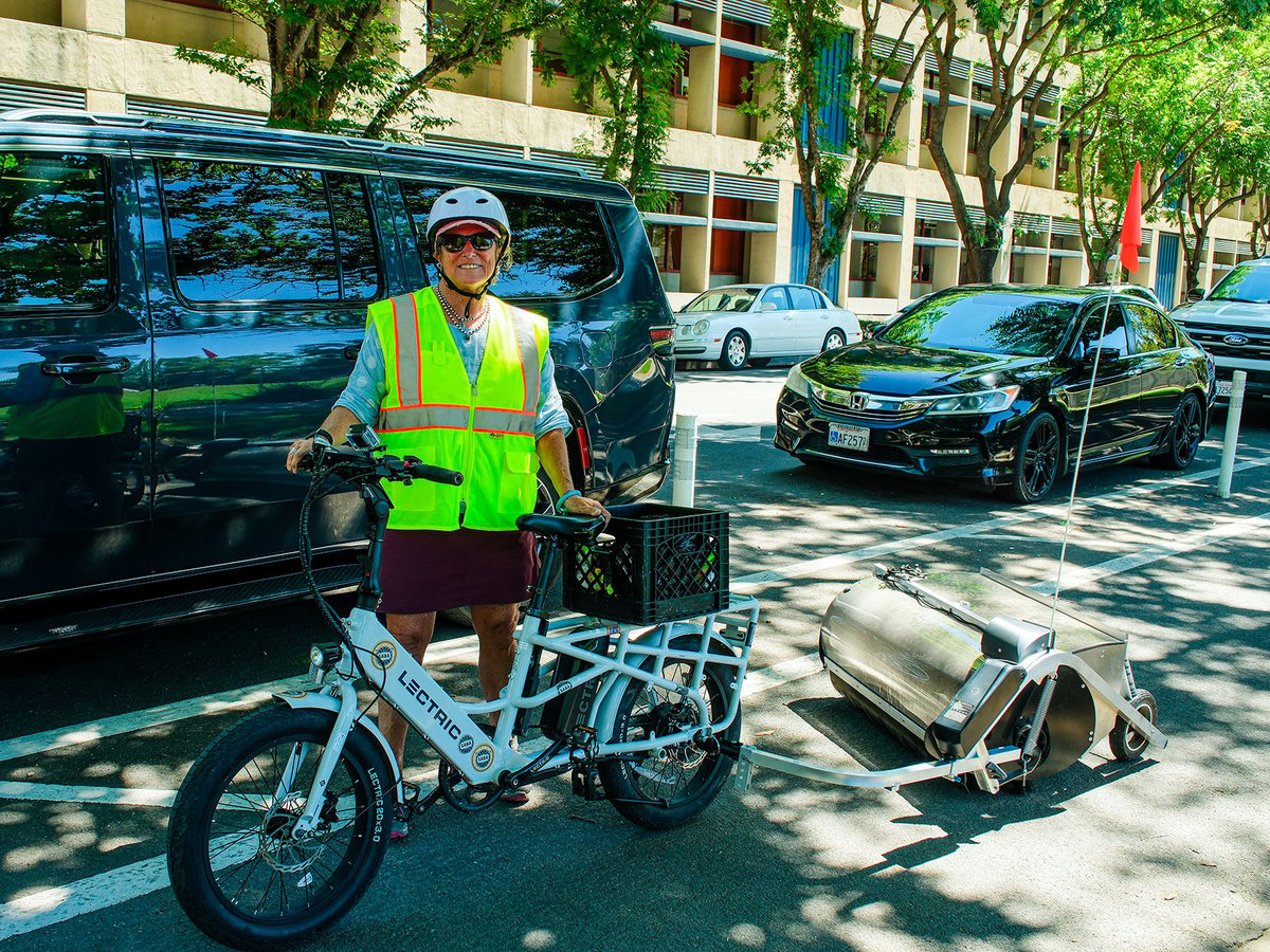 Sacramento Area Bike Advocates Policy and Advocacy Director Deb Banks stands with Crunch, the bike lane cleaner on July 16, 2026.