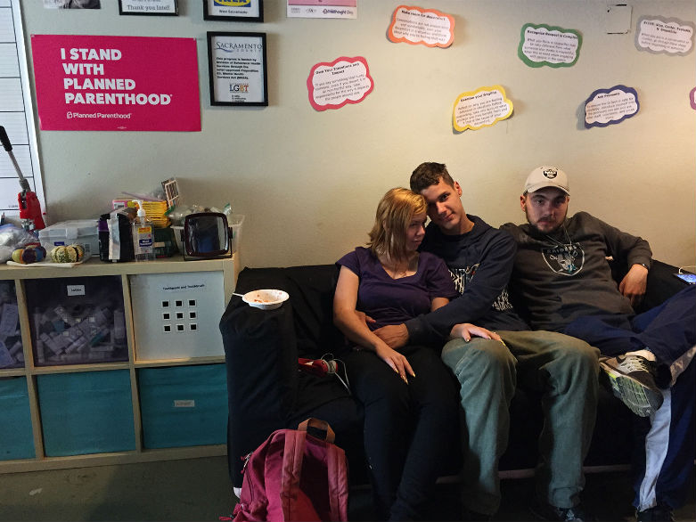 Colin Jackson (center) watches TV with his friends at the LGBT Center in Sacramento. 