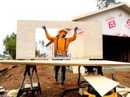 Jose Villanueva carries siding while building a home, Wednesday, Oct. 25, 2023, in Paradise, Calif. Most of the town burned in late 2018.