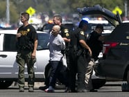 A suspect believed to be involved in the shooting of law enforcement officers is taken from the scene by Sacramento County Sheriff's Deputies, Wednesday, Aug. 30, 2017, in Sacramento, Calif.
