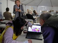 Pacific Gas & Electric Co. employee Amara Hayashida, left, helps a resident locate his residence on a map to see if he will be impacted by a possible power outage at a PG&E community resource center on Monday, Oct. 28, 2019, in Berkeley, Calif.
