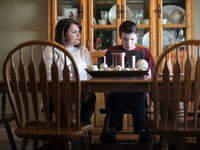 Linda Soares, left, helps her son, Daniel, 16, with his history homework at their dining room table. Soares says that she has been able to learn from her son’s school aid, who is a friend, on how to best assist him with his class work.