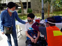 In this May 14, 2021, file photo, Colin Sweeney, 12, gets a shot of the Pfizer COVID-19 vaccine as his mother Nicole pats his shoulder at the First Baptist Church of Pasadena in Pasadena, Calif.