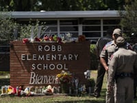 Flowers and candles are placed outside Robb Elementary School in Uvalde, Texas, on Wednesday to honor the victims killed in Tuesday's shooting at the school.