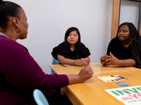 Nakeya Bell with the nonprofit Youth Forward, speaks to two students in her IQ Squad program, Amari Haysbert and Jenalyn Phanh. Bell’s program, IQ Squad focuses on getting women of color increased access to culturally-grounded mental health support.