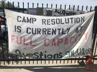 Signs cover the fences surrounding Camp Resolution, a sanctioned encampment in North Sacramento on April 6, 2023.