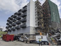 In this June 18, 2021, photo, construction workers finish the exterior of an apartment building downtown Los Angeles.