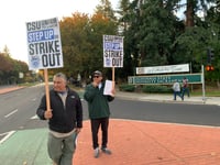 Alejandro Raya, a Sacramento State garage employee, and Raul Echeverria, a Sac 
State facilities supervisor, hold strike signs outside of the university's entrance on J Street on Nov. 11, 2023.