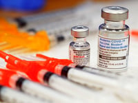 Pfizer, left, and Moderna bivalent COVID-19 vaccines are readied for use at a clinic, Nov. 17, 2022, in Richmond, Va.
