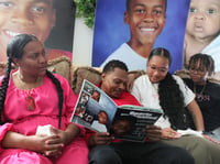 The Robinson family looks at photos of Yahushua Robinson, a 12-year-old boy who loved to sing, dance, and give everyone a smile.
