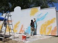 Artist Karen Tsugawa paints color splashes onto a wall in Downtown Sacramento on Friday, May 10, 2024. The final mural dedicated to the history of Sacramento Japantown will feature artwork panels based on photographs taken between the 1940s and '60s.