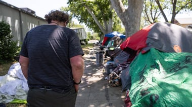 Damian Newton walks to his tent in Midtown Sacramento on Tuesday, May 30, 2023.
