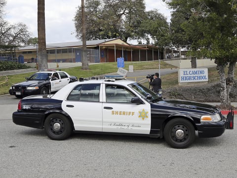 LA County Sheriff's patrol cars leave El Camino High School in Whittier, Calif., on Wednesday. A 17-year-old student threatened to open fire at the school days after the massacre at a Florida school.